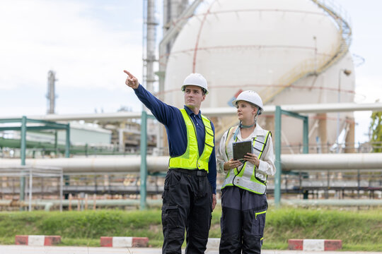 Two petroleum engineers having a discussion at oil refinery site