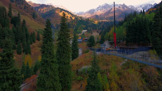 Cinematic autumn landscape of Almaty, Kazakhstan, featuring colorful mountain scenery, snowy Tien Shan peaks, Shymbulak ski resort, Medeu and the cable car.