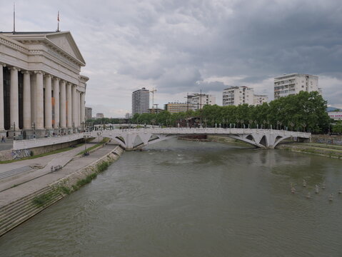 View of the Bridge of Civilizations spanning the Vardar River with the neoclassical Archaeological Museum in the background in Skopje, Greater Skopje, North Macedonia.