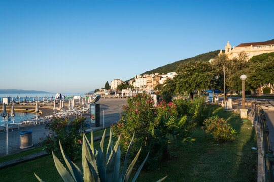 View of the coastal promenade with lush greenery, palm trees, and historic buildings along the Adriatic Sea in Opatija, Primorje-Gorski Kotar, Croatia.