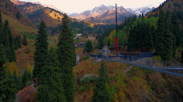 Cinematic autumn landscape of Almaty, Kazakhstan, featuring colorful mountain scenery, snowy Tien Shan peaks, Shymbulak ski resort, Medeu and the cable car.