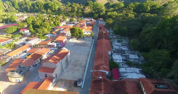 Aerial view of the village of Cepe with red-tiled roofs and a central plaza surrounded by lush greenery in Maracay, Aragua, Venezuela.
