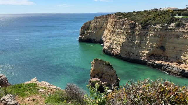 Sunny Algarve coastline at Praia do Vale Covo near Carvoeiro Portugal, turquoise sea water, impressive limestone cliffs and natural rock formations overlooking Atlantic Ocean