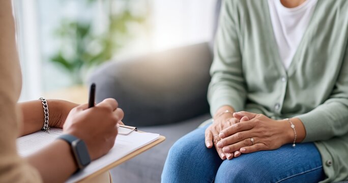 Therapy session with therapist taking notes on clipboard during a counseling interview of patient