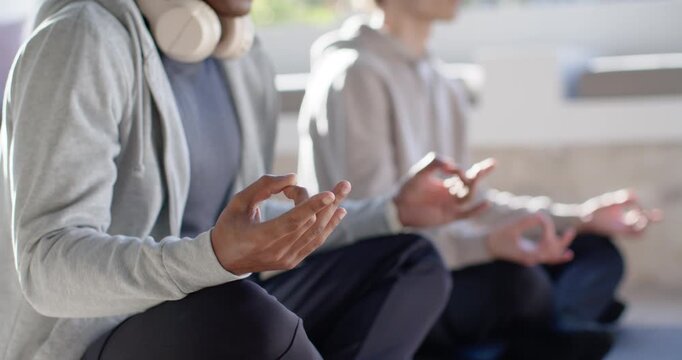 Hands in mudra two males sitting balcony hoodies headphones opening palms raising arms for calm
