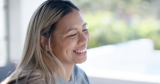 African American woman smiling, laughing softly, turning head right by glass door in grey top