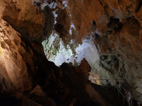 View of Vrelo Cave featuring intricate stalactites and stalagmites with visitors walking along a metal staircase in Matka, Komuna e Sopishtes, North Macedonia.