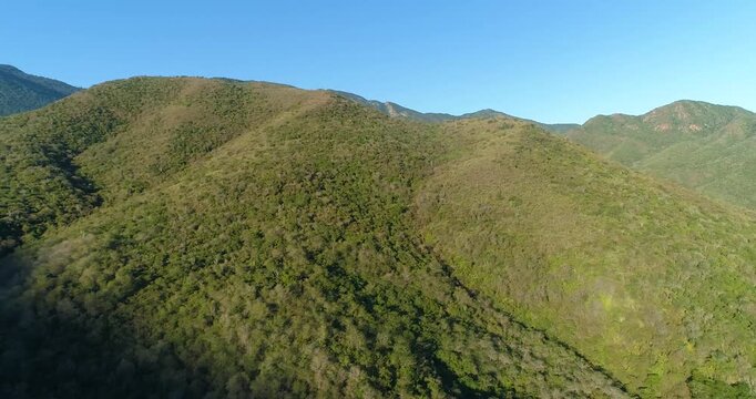 Aerial view of lush green mountains of Cepe under a clear blue sky in Maracay, Aragua, Venezuela.