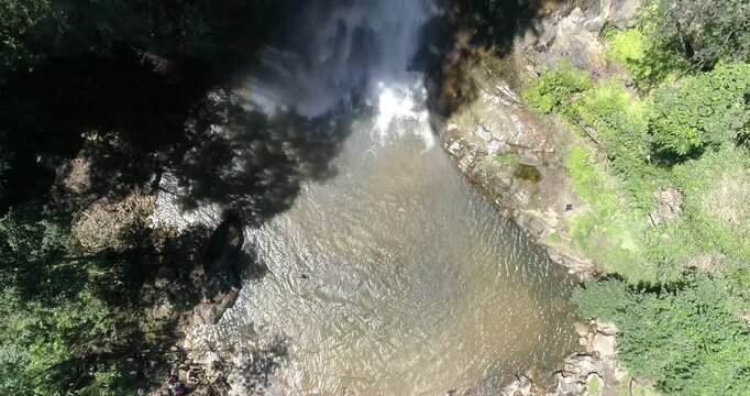 Aerial view of waterfall cascading into a natural pool surrounded by dense tropical forest Maracay, Aragua, Venezuela.