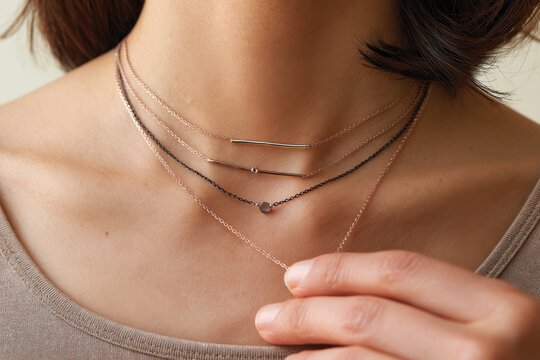 A detailed view of layered necklaces in rose gold, demonstrating the artistry behind jewelry design and its ability to elevate any outfit with elegance and charm.