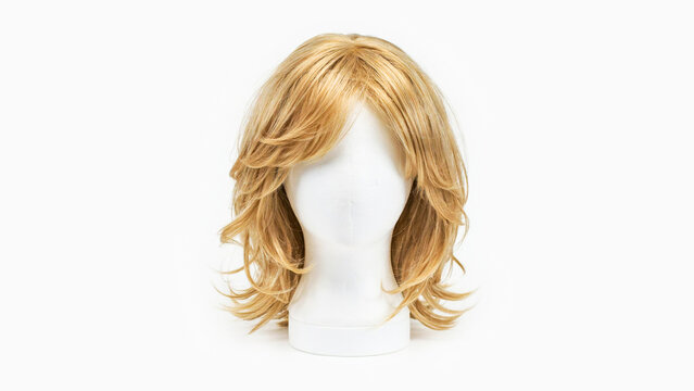 Synthetic blonde wig with layered medium length hair on white mannequin head isolated on white background for fashion and hair styling