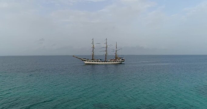 Aerial view of the tall ship Buque Escuela Simon Bolivar sailing in the turquoise waters of the Los Roques archipelago in Los Roques, Dependencias Federales, Venezuela.