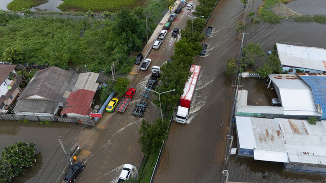 An elevated view of a flooded road with vehicles driving through the water.