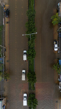 An elevated view of a flooded road with vehicles driving through the water.