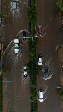 An elevated view of a flooded road with vehicles driving through the water.