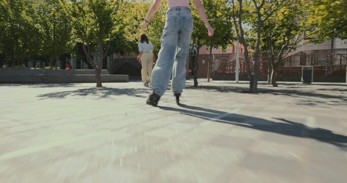 Energetic young woman rollerblades toward moving follow camera across sunny city plaza with confidence. Youth lifestyle, urban fitness and recreation concept.