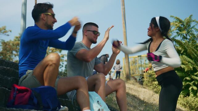 Cheerful young adults participate in an outdoor fitness session. They share a fun moment while exercising together.