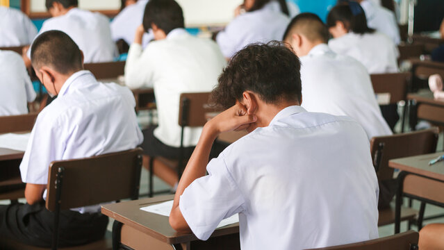 Stressed Students Taking Final Examination in Classroom