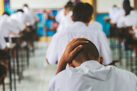 Stressed Student Holding Head During Final Exam in Classroom