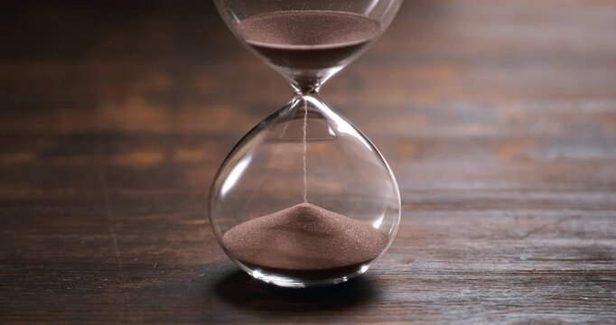Hourglass at 1000 fps with sand falling in mesmerizing slow motion, evoking the passage of time, mortality, patience and the fleeting beauty of every moment.