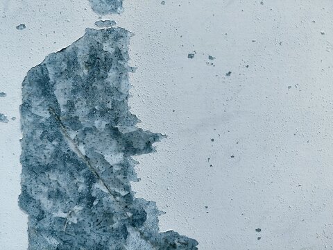 Weathered and peeling white paint on galvanized metal texture