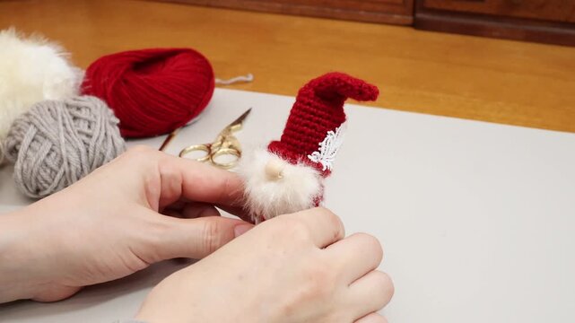 北欧の妖精トムテを毛糸で手作り　完成作品を見ながら楽しむ様子