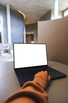 Vertical mockup image of a woman working on laptop computer with blank white desktop screen
