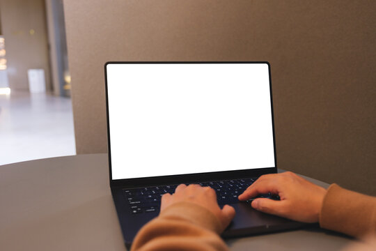 Mockup image of a woman working and typing on laptop computer with blank white desktop screen
