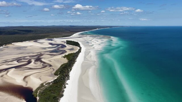 Aerial view of Wathumba Creek featuring winding tidal channels and white sandbars along the turquoise coastline of K'gari, Hervey Bay, Queensland, Australia.