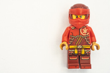 Obraz premium Close up of a Kai lego mini figure from the Ninjago series, shot isolated on a white paper background. Seen here wearing a red ninja face covering. Bradford, UK.Sep 28 2026