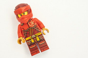 Obraz premium Close up of a Kai lego mini figure from the Ninjago series, shot isolated on a white paper background. Seen here wearing a red ninja face covering. Bradford, UK.Sep 28 2026