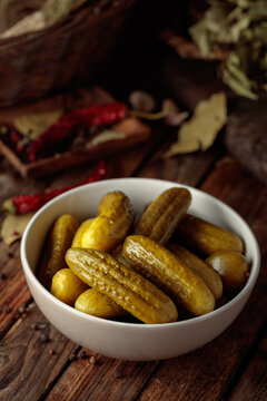 Homemade canned gherkins on a rustic wooden background.