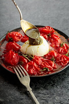 Mozzarella with pesto sauce and roasted red cherry tomatoes.