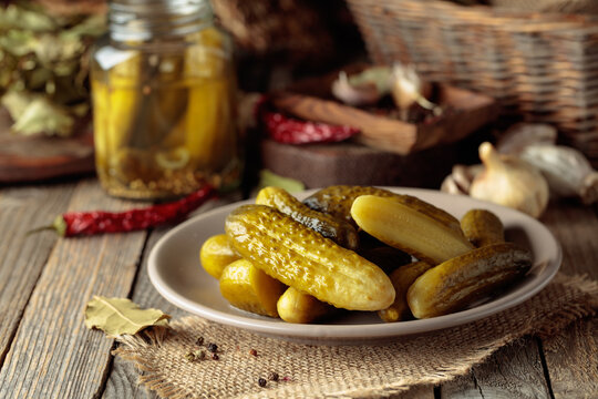 Homemade canned gherkins on a rustic wooden background.