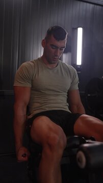 Muscular athlete training legs on extension machine