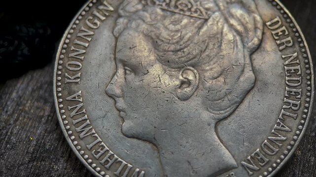 Macro detail video of an antique 1898 Dutch 2.5 gulden crown pattern coin, featuring a crowned female portrait, aged silver surface, fine engraved hair and facial details.