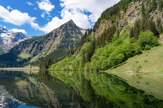 Scenic nature view over mountain lake. Reflective lake with mountain landscape. Landscape of mountain peak and valley lake. Nature landscape. Lake in wild nature forest scenery. Summer landscape
