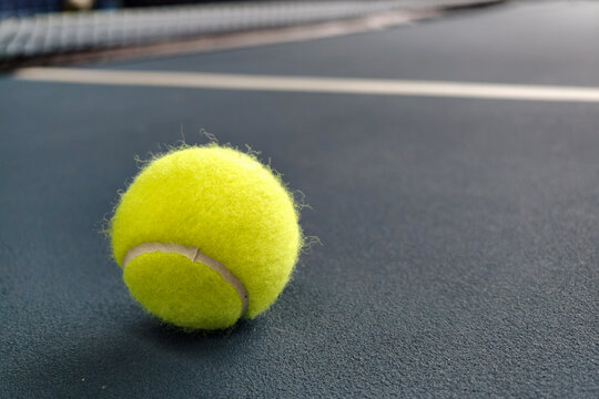 Tennis ball on a blue court surface