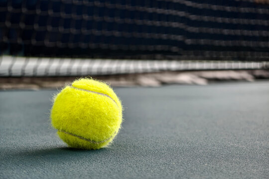Tennis ball on a blue court surface
