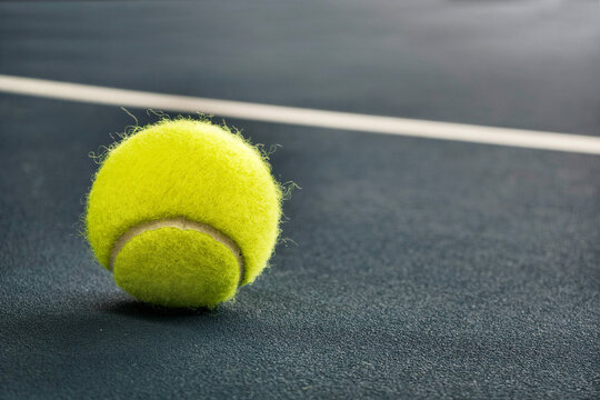 Tennis ball on a blue court surface