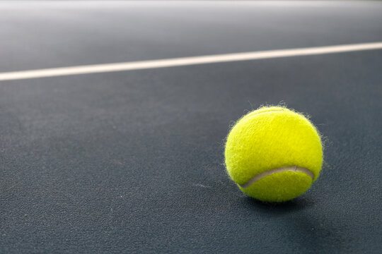 Tennis ball on a blue court surface