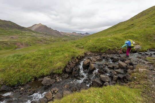 Girl crossing stream, Br&uacute;nav&iacute;k, V&iacute;knasl&oacute;dir, Iceland