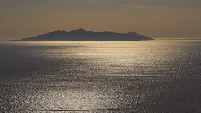 Morning atmosphere, islets in the morning backlight, sun reflections on the water, Old Thera, mountain peaks, archaeological site, Perissa, Kamari, Santorini Island, Cyclades, Greece
