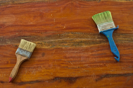 Paint brushes on a textured wooden surface, representing creativity, craftsmanship, home improvement, artistic work and DIY projects.
