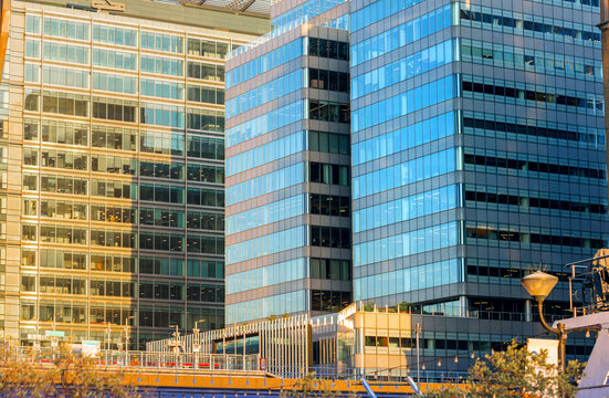 London, Sunset in docklands. Canary Wharf North dock skyscrapers, banks and office buildings with golden light reflections
