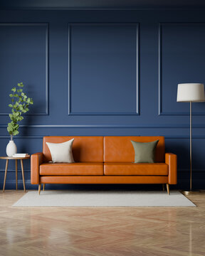 Vertical navy blue living room with caramel leather sofa and wall moldings