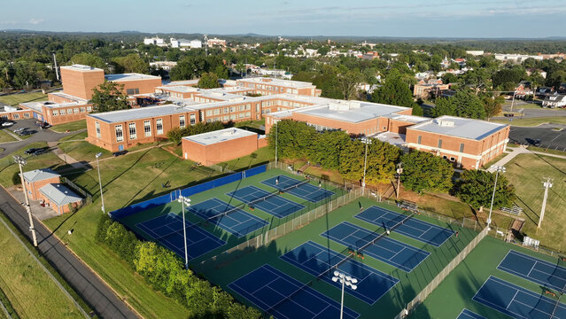 Aerial view of a school campus with red brick buildings and multiple blue tennis courts in Lynchburg, Virginia, United States.