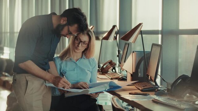 Business Colleagues Working Together Reviewing Documents In Modern Office. Corporate Teamwork. Corporate Discussion Paperwork