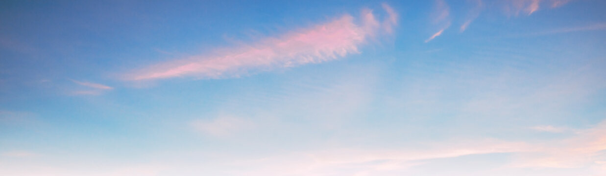 Soft clouds drift across serene blue sky