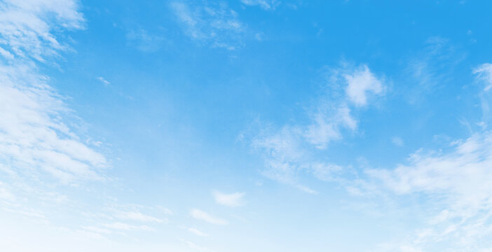 Clear blue sky with soft, wispy clouds